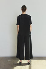 Back view of the black silk crepe Kamperett Jette Silk Crepe Tee showing the reversible construction and shoulder darts.