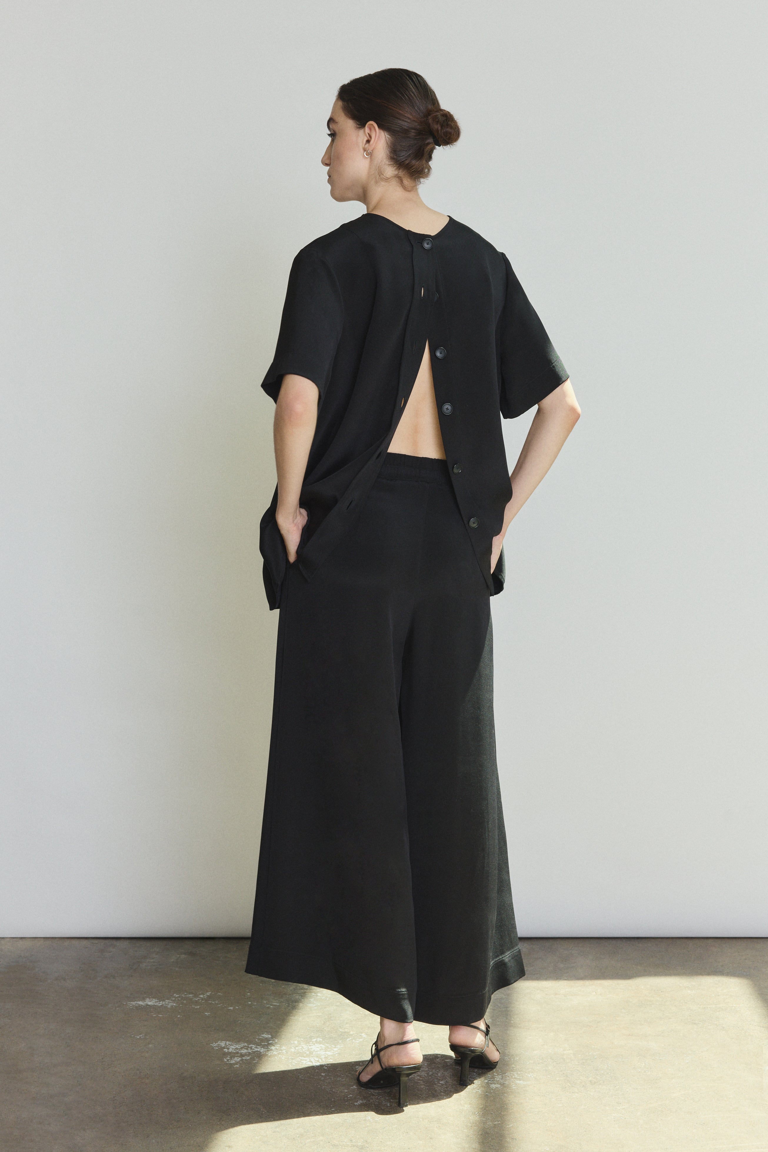 Model wearing the black Kamperett Jette Silk Crepe Tee styled with the Alix Silk Crepe Pant in Black.