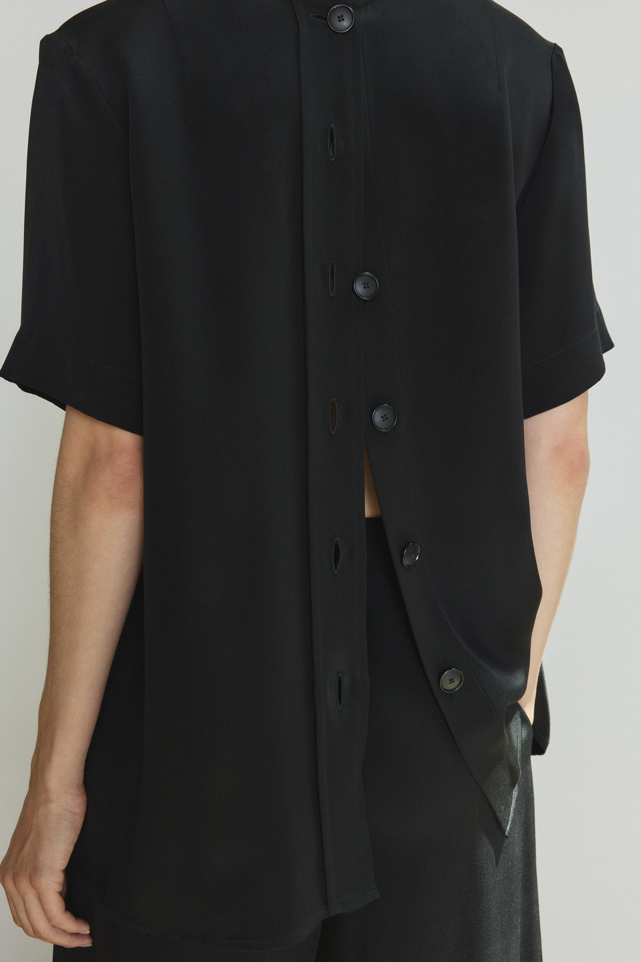 Editorial image of the black Kamperett Jette Silk Crepe Tee styled with the Alix Silk Crepe Pant in Black.