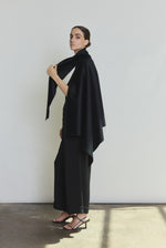 Detail of the black cashmere Kamperett Joan Cape showing the attached scarf and selvedge finishing.