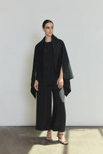 Side view of the black cashmere Kamperett Joan Cape showing the darted shoulder construction and attached scarf.
