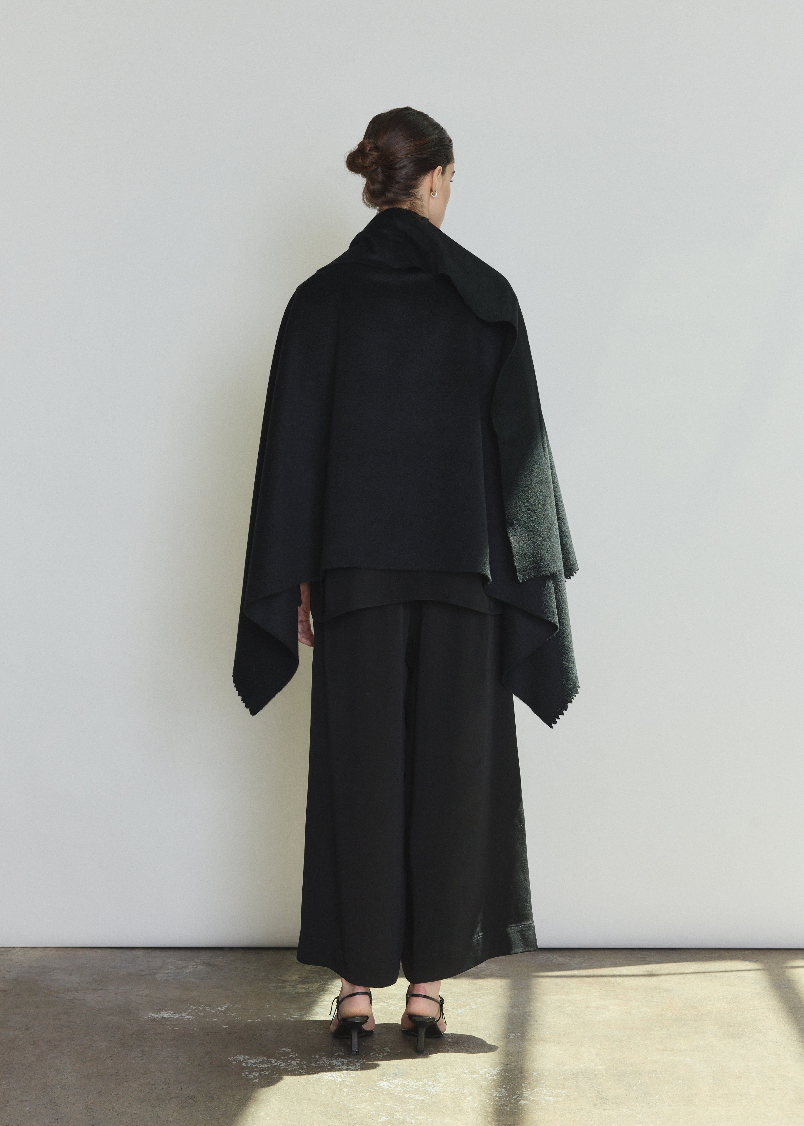 Model wearing the black Kamperett Joan Cashmere Cape styled with the Alix Silk Crepe Pant in Black.