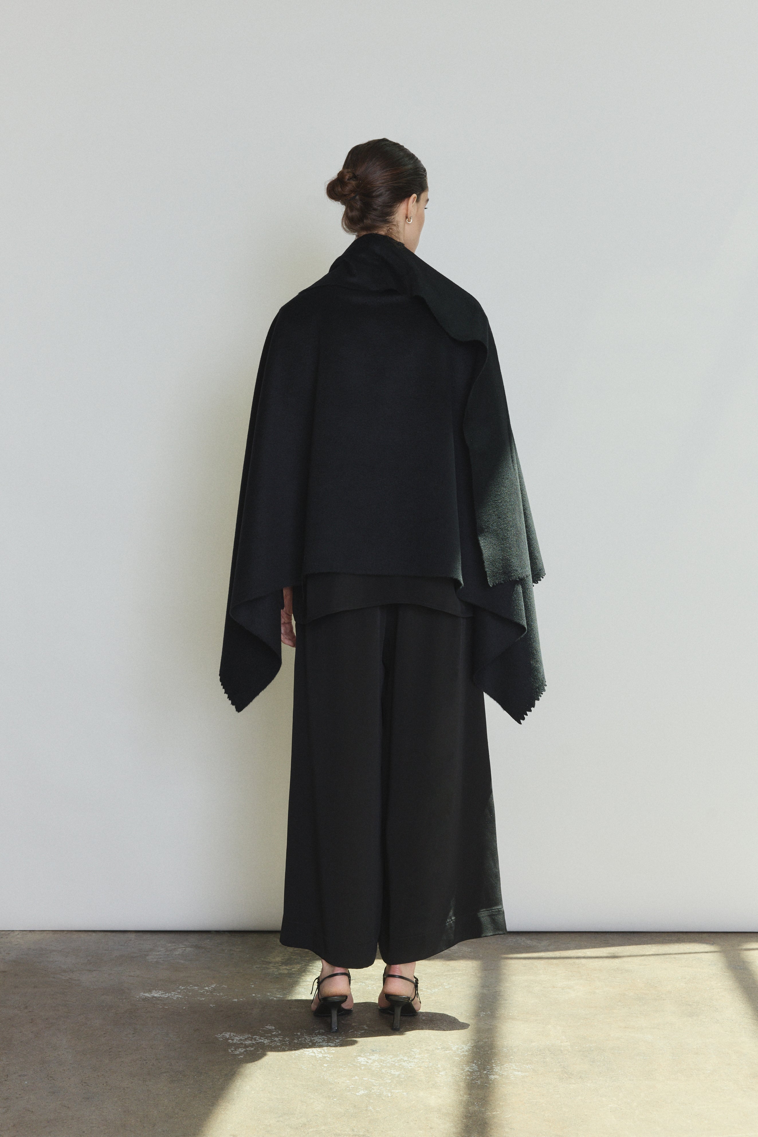 Model wearing the black Kamperett Joan Cashmere Cape styled with the Alix Silk Crepe Pant in Black.