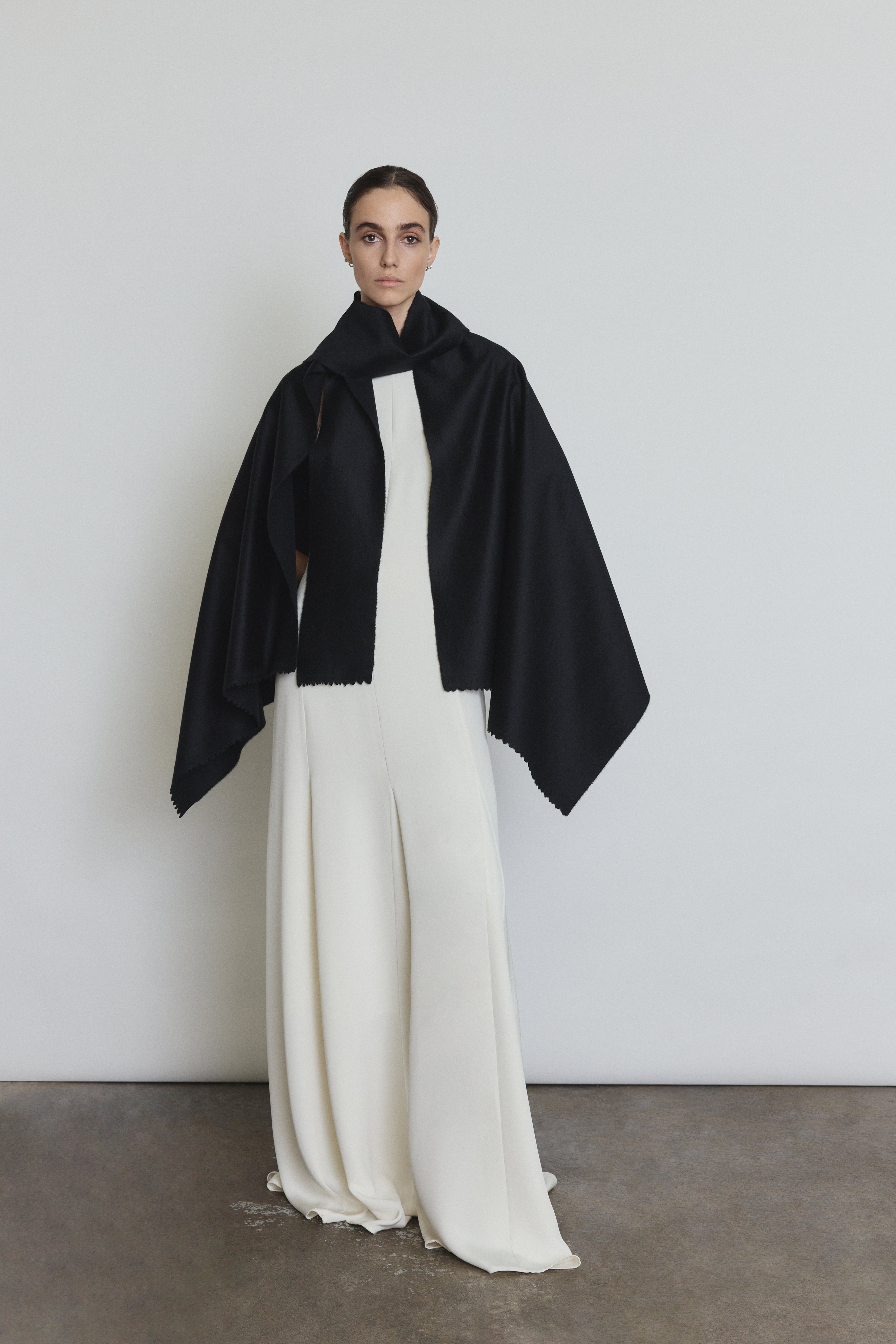 Bride wearing the black Kamperett Joan Cashmere Cape draped over the Ray Gown in Alabaster.