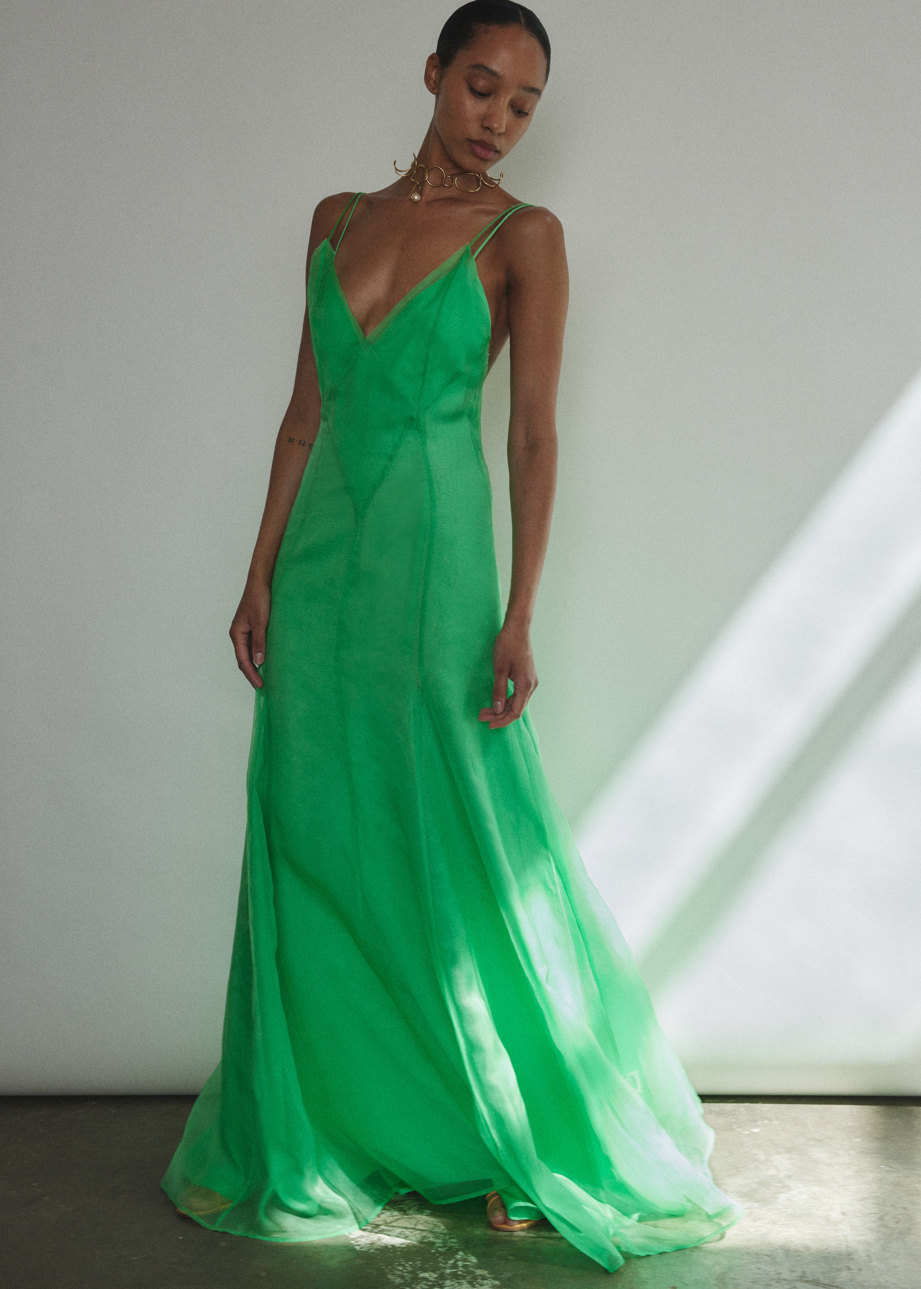 Angled view of the celadon silk organza Kamperett Lalique Gown styled with Simone Slip in Buff or Celadon.