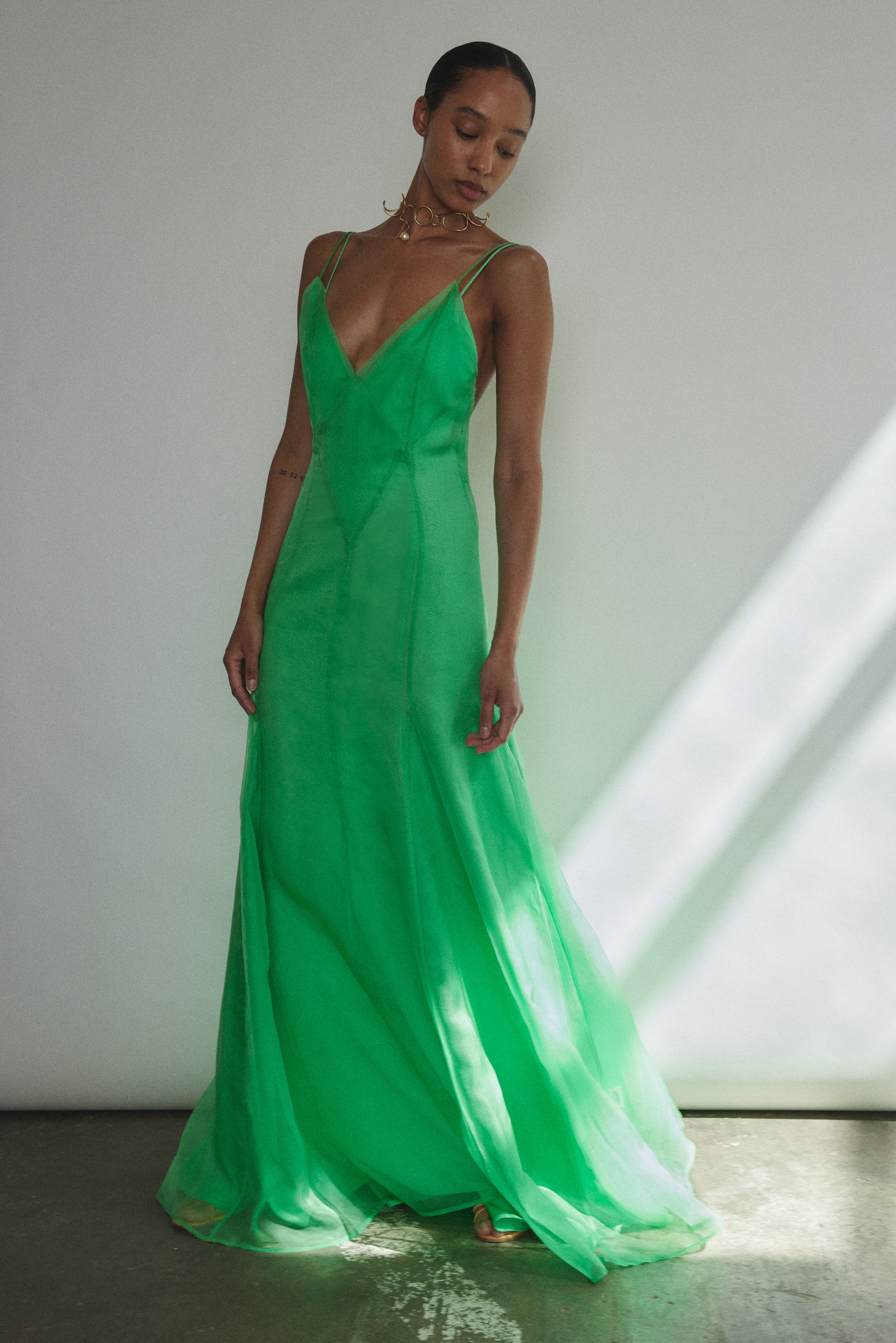 Angled view of the celadon silk organza Kamperett Lalique Gown styled with Simone Slip in Buff or Celadon.