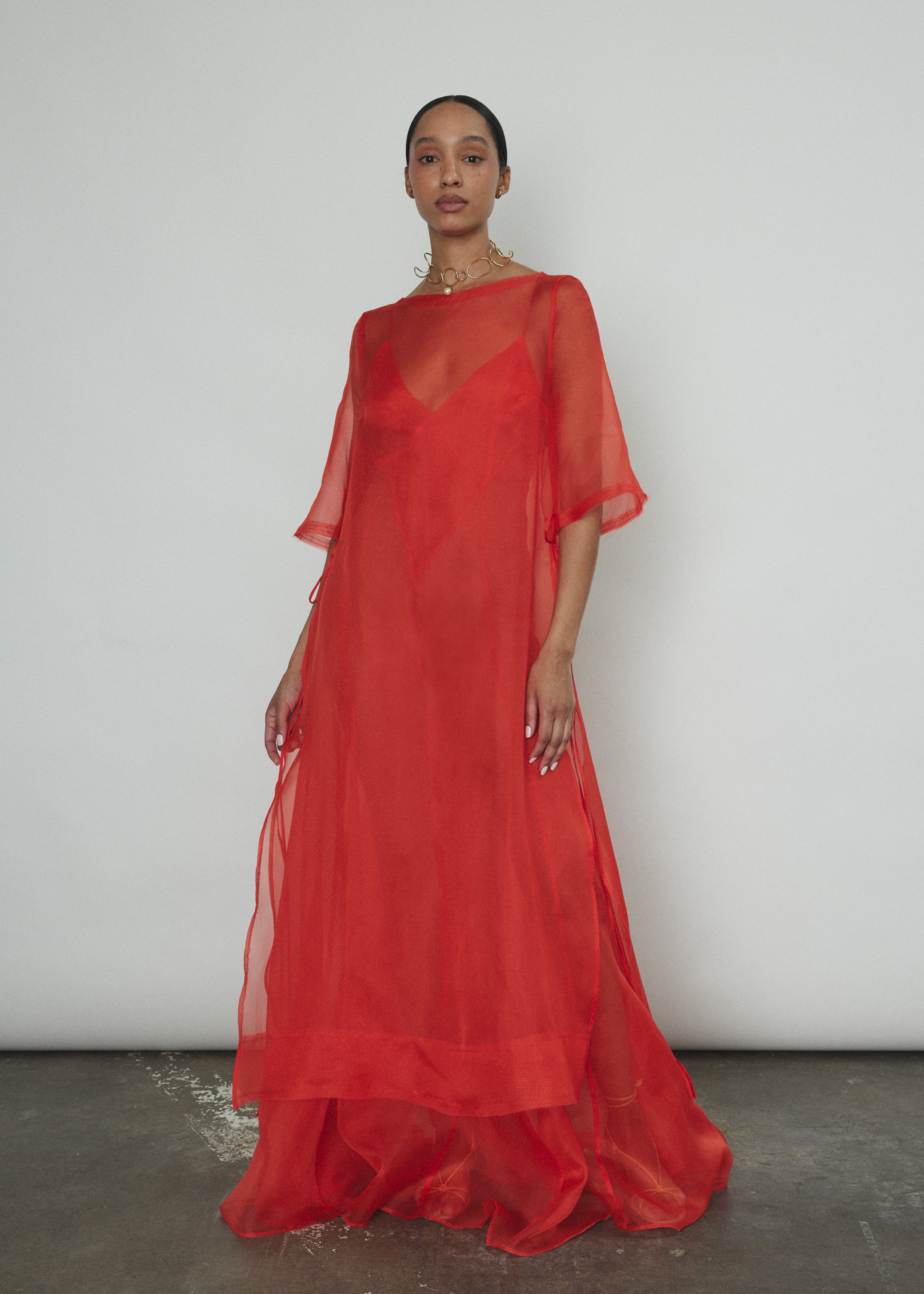 Angled view of the vermilion silk organza Kamperett Lalique Gown showing the intricately seamed construction.