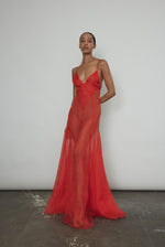 Front view of a model wearing the vermilion silk organza Kamperett Lalique Gown, a sheer V-neck maxi with multi-godet skirt.