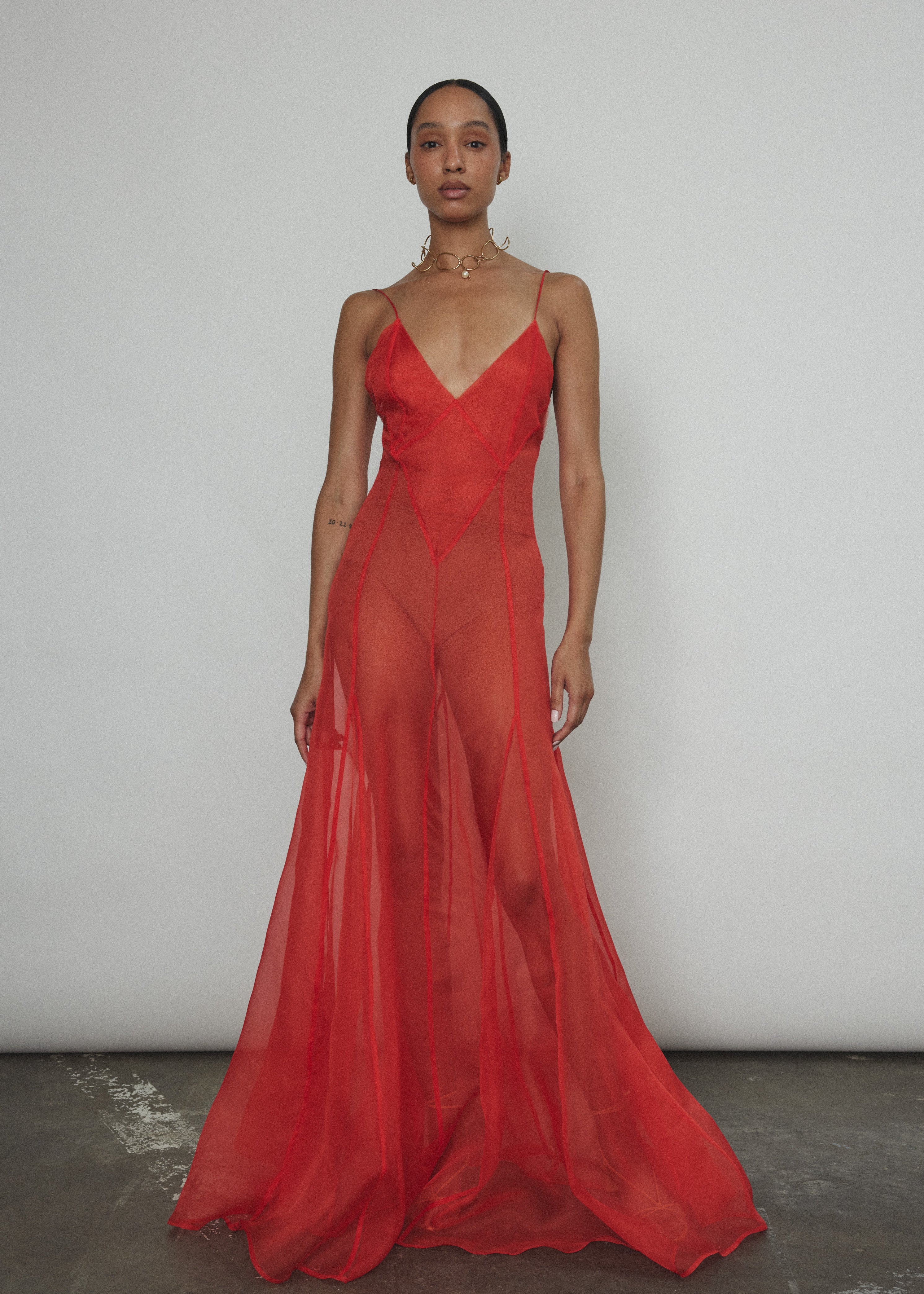 Side view of the vermilion silk organza Kamperett Lalique Gown with corded straps and sheer drape.