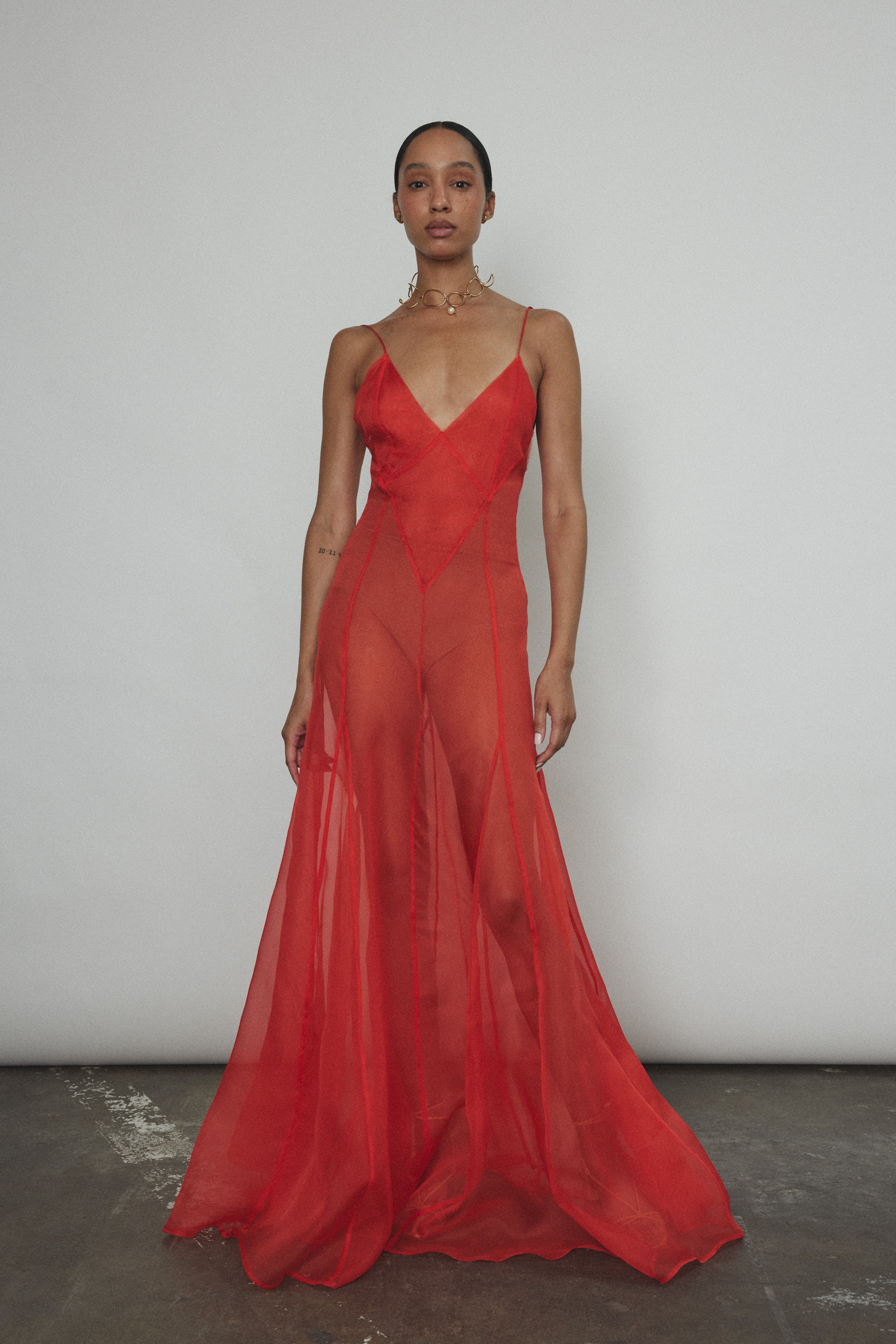Side view of the vermilion silk organza Kamperett Lalique Gown with corded straps and sheer drape.