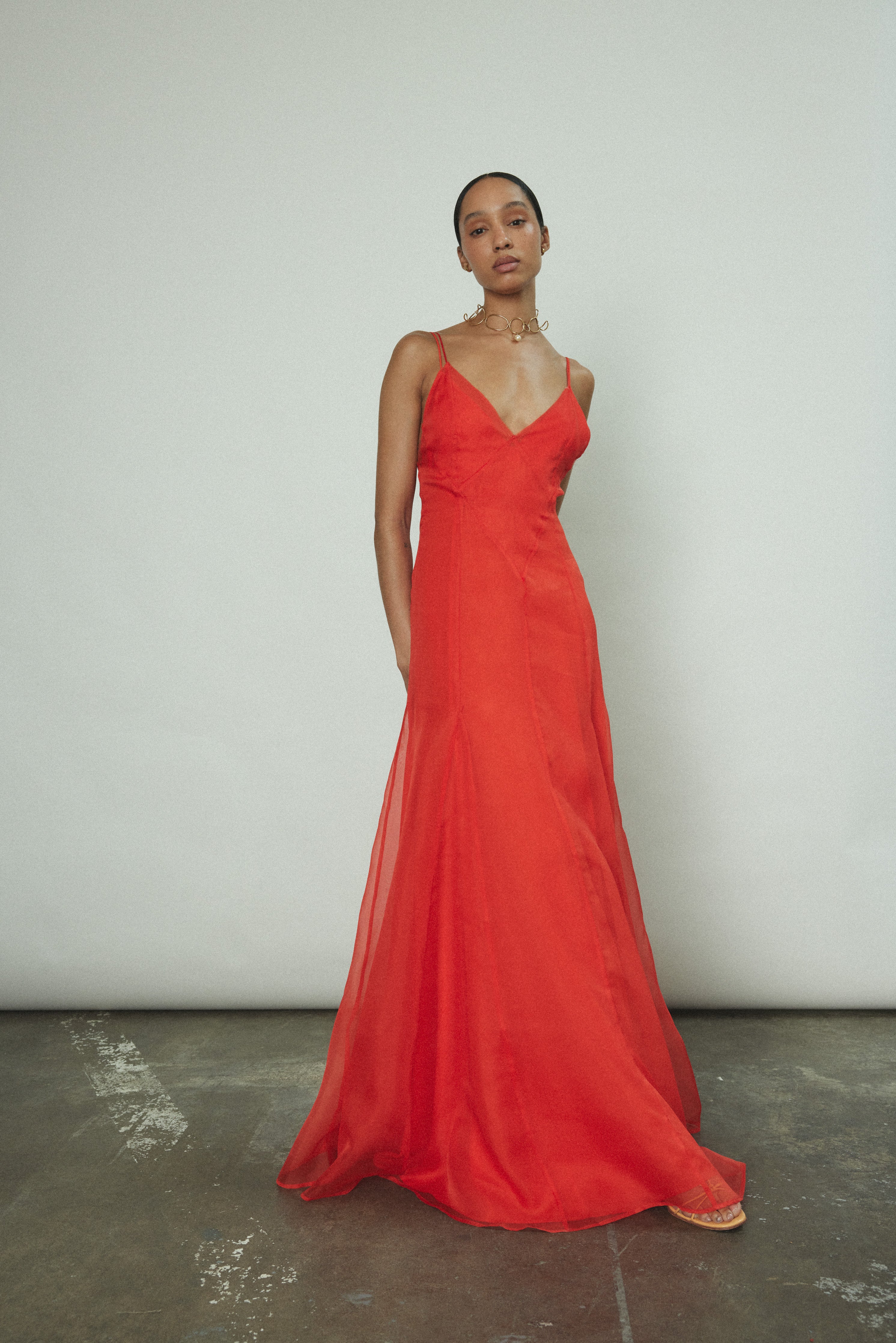 Model wearing the vermilion Kamperett Lalique Gown layered over the Simone Slip Dress.