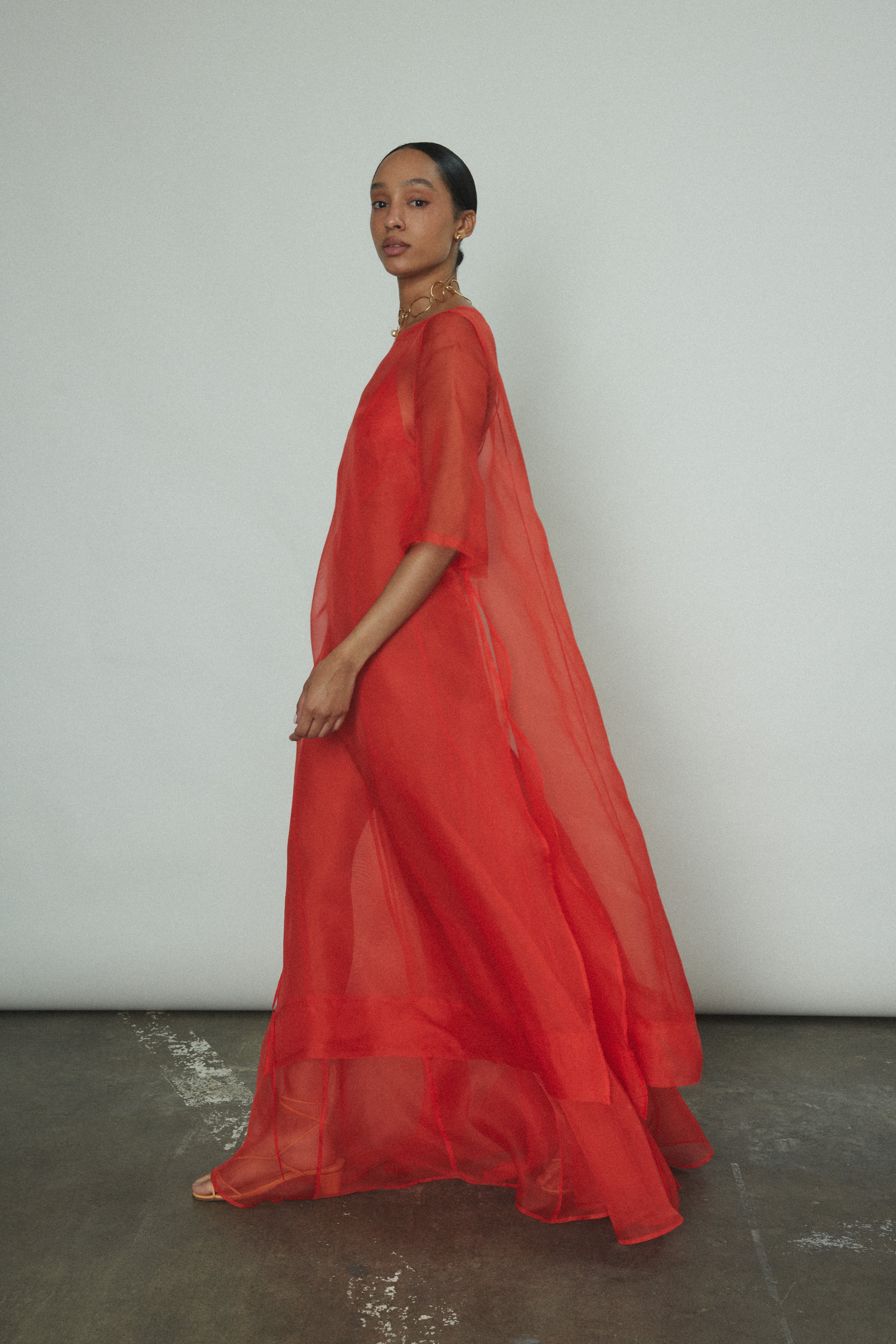 The vermilion Kamperett Lalique Gown styled over the Thea Sheath Dress for a layered occasion look.