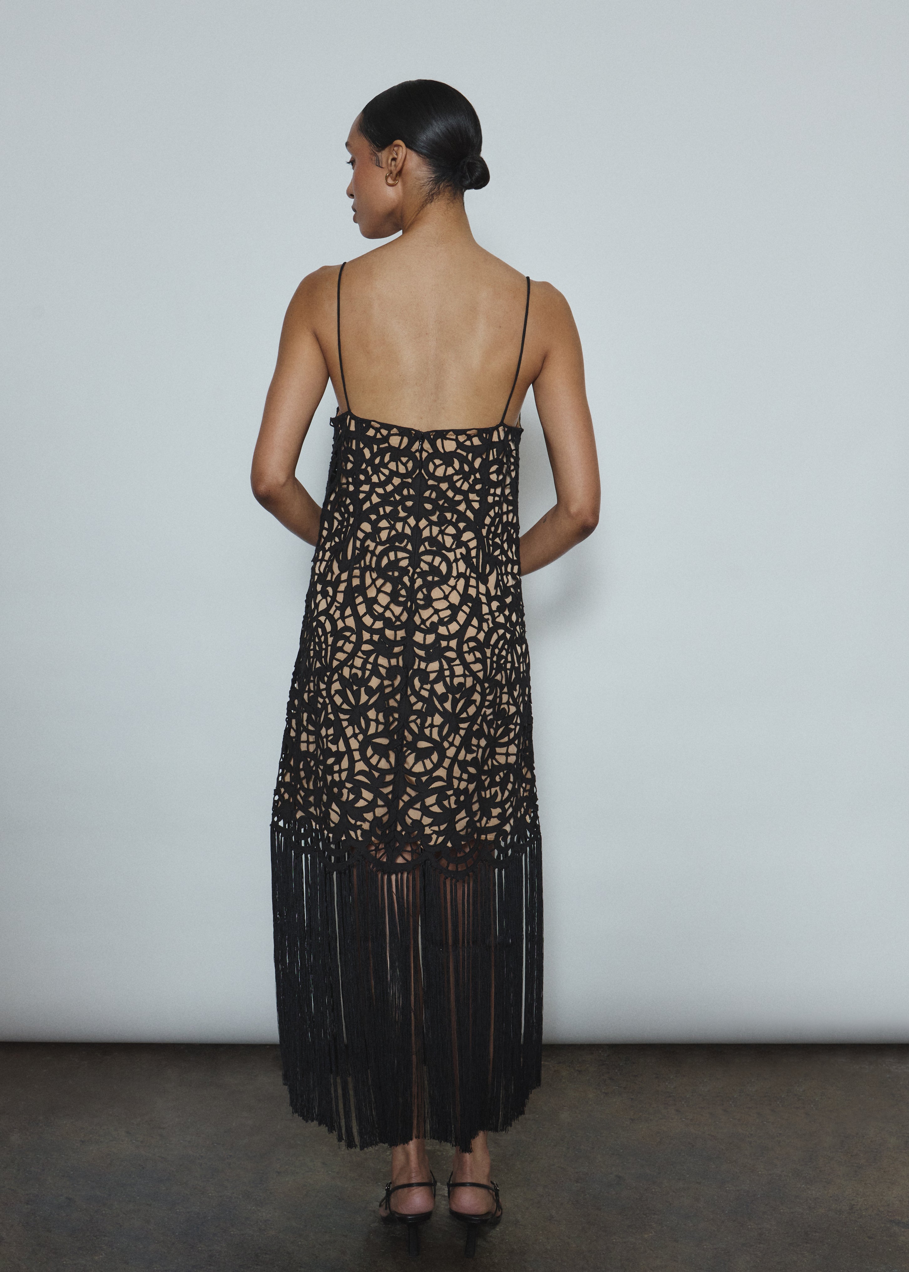 Back view of the black cotton openwork Kamperett Lenore Dress with invisible center-back zip and spaghetti straps.