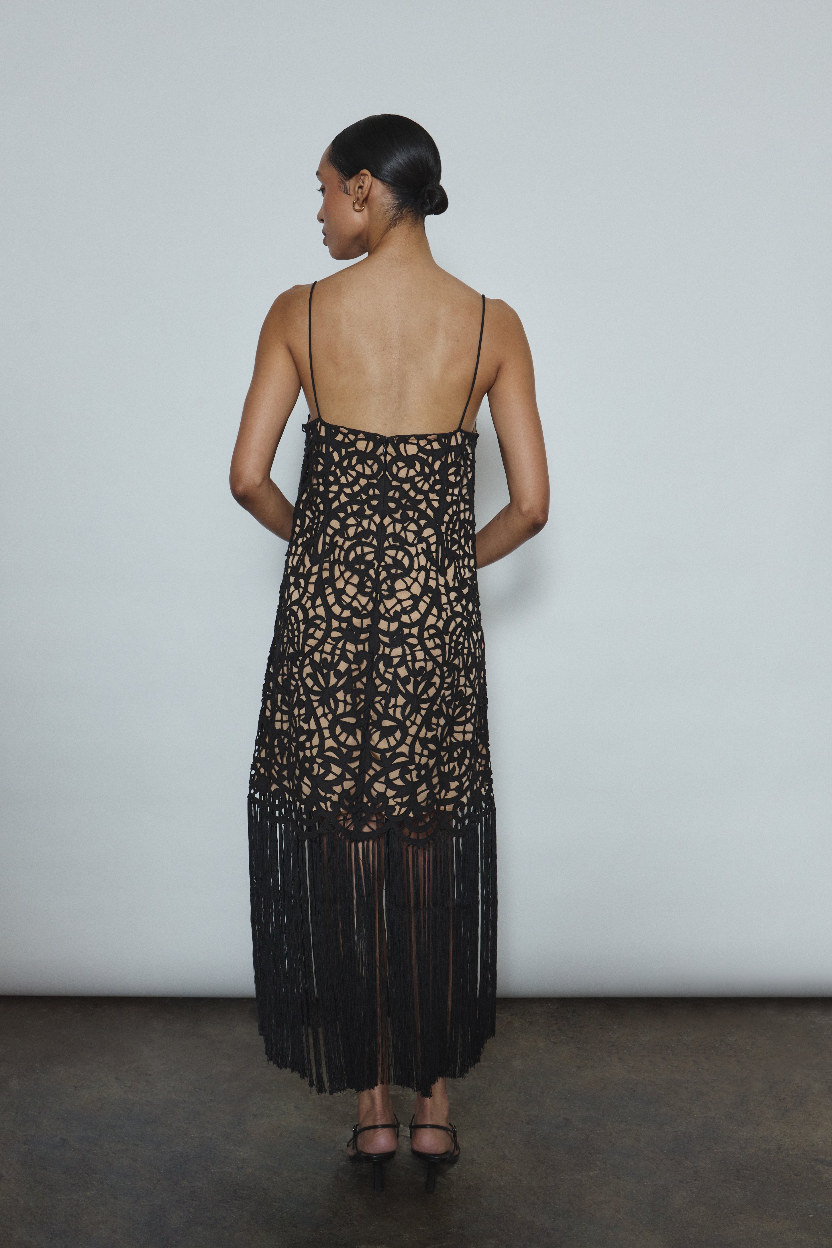 Back view of the black cotton openwork Kamperett Lenore Dress with invisible center-back zip and spaghetti straps.