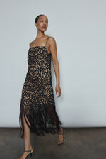 Editorial image of a model wearing the black Kamperett Lenore Dress, a modern occasion A-line midi with openwork motif.