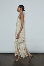 Detail of the intricately cut openwork cotton motif and hand-applied fringe on the cream Kamperett Lenore Dress.
