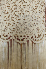 Editorial image of the cream Kamperett Lenore Dress styled with motion, showing the A-line silhouette and fringe.