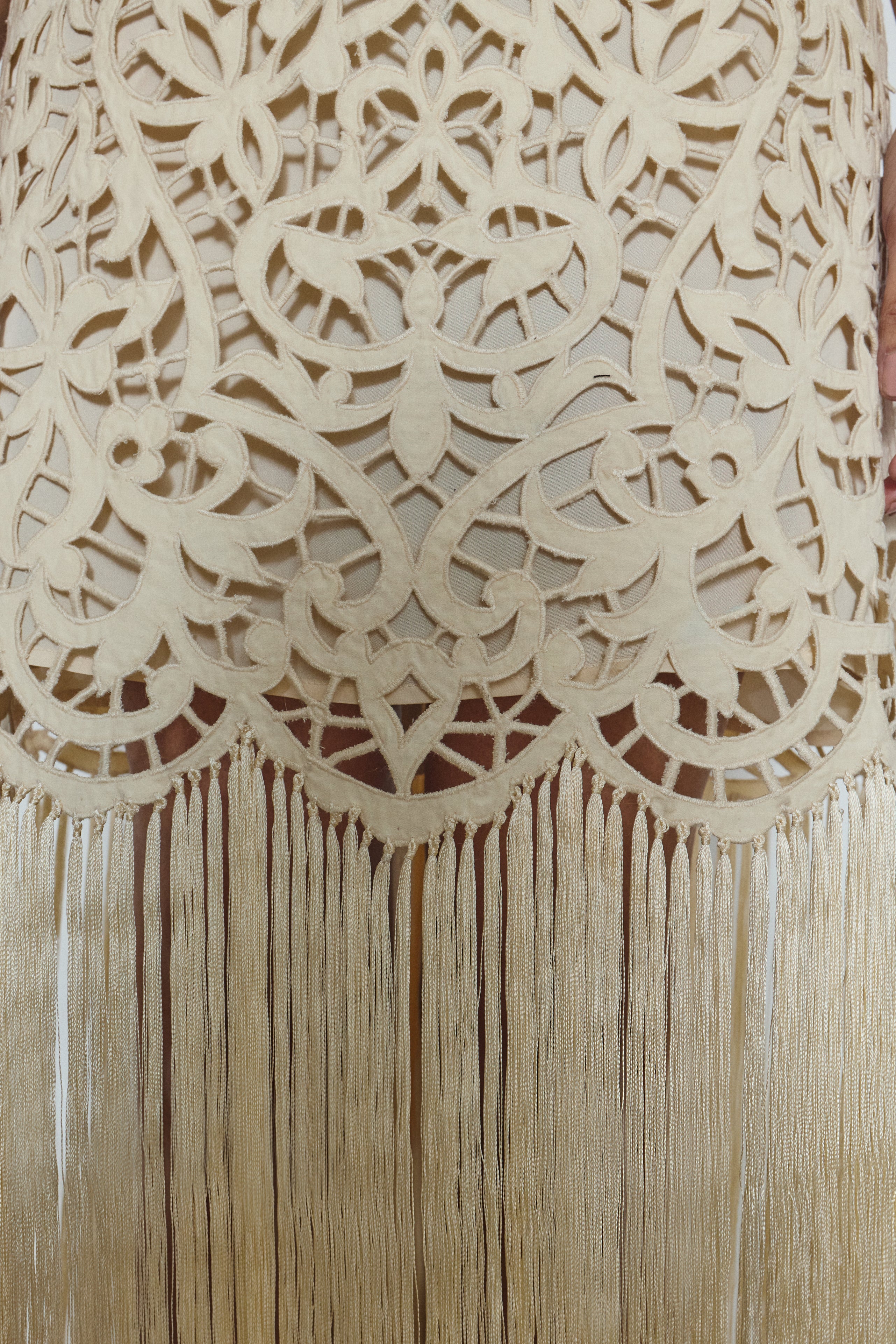 Editorial image of the cream Kamperett Lenore Dress styled with motion, showing the A-line silhouette and fringe.