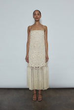 Front view of a bride wearing the cream cotton openwork Kamperett Lenore Dress, an A-line midi with square neckline, spaghetti straps, and hand-applied fringe.