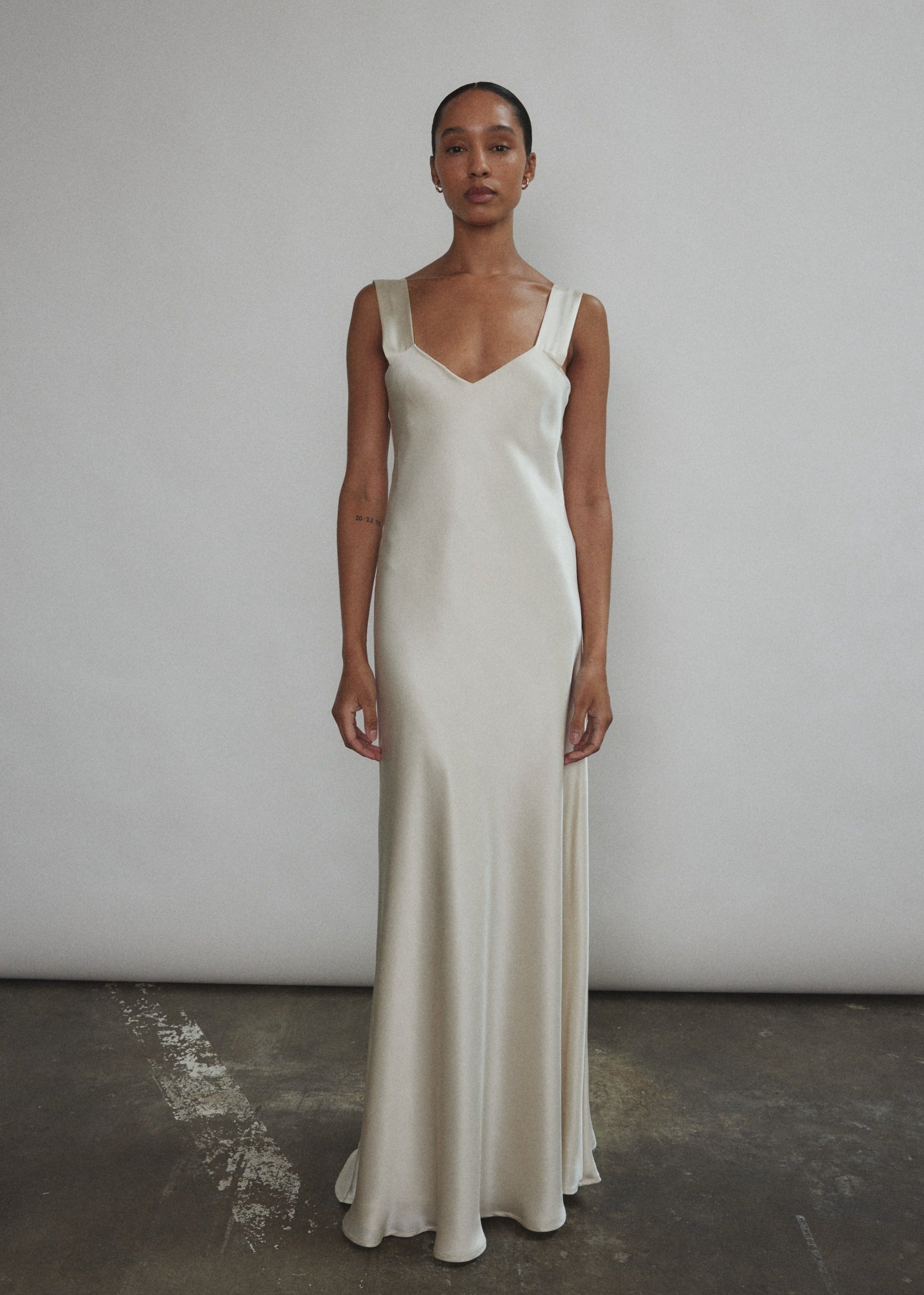 Front view of a model wearing the ivory silk charmeuse Kamperett Lisette Maxi Slip Dress, a bias-cut V-neck minimalist wedding slip.