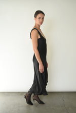 Angled view of the black silk charmeuse Kamperett Lisette Midi Slip Dress with V-neck detail.