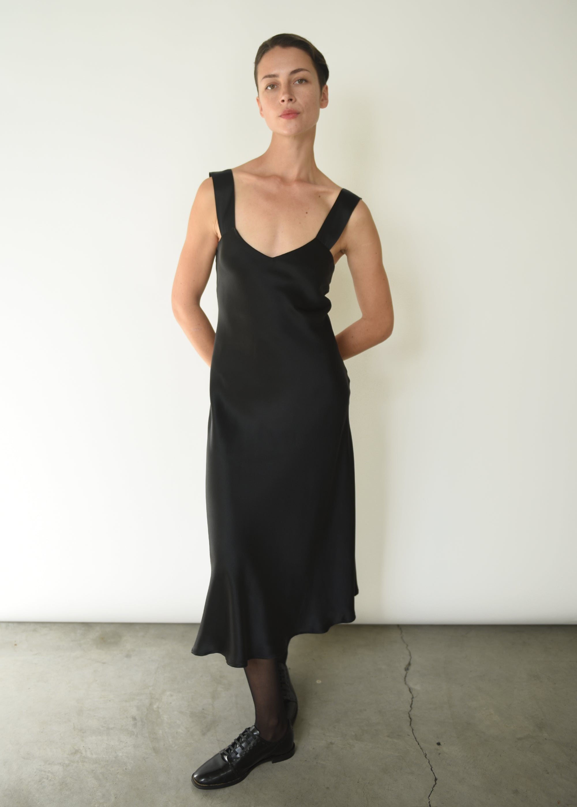 Editorial image of the black silk charmeuse Kamperett Lisette Midi Slip Dress.