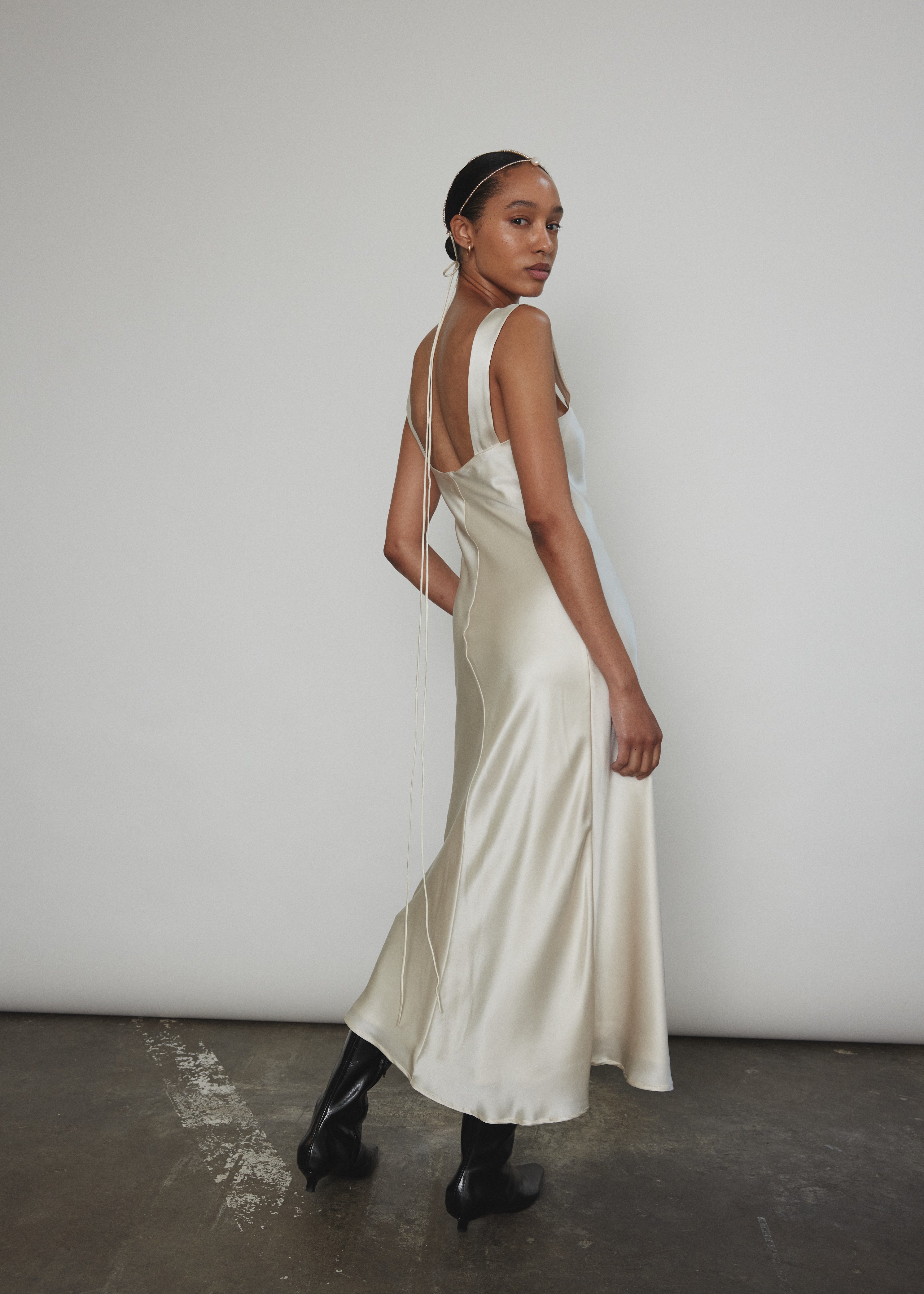 Back view of the ivory silk charmeuse Kamperett Lisette Midi Slip Dress with straight-cut back and wider straps.