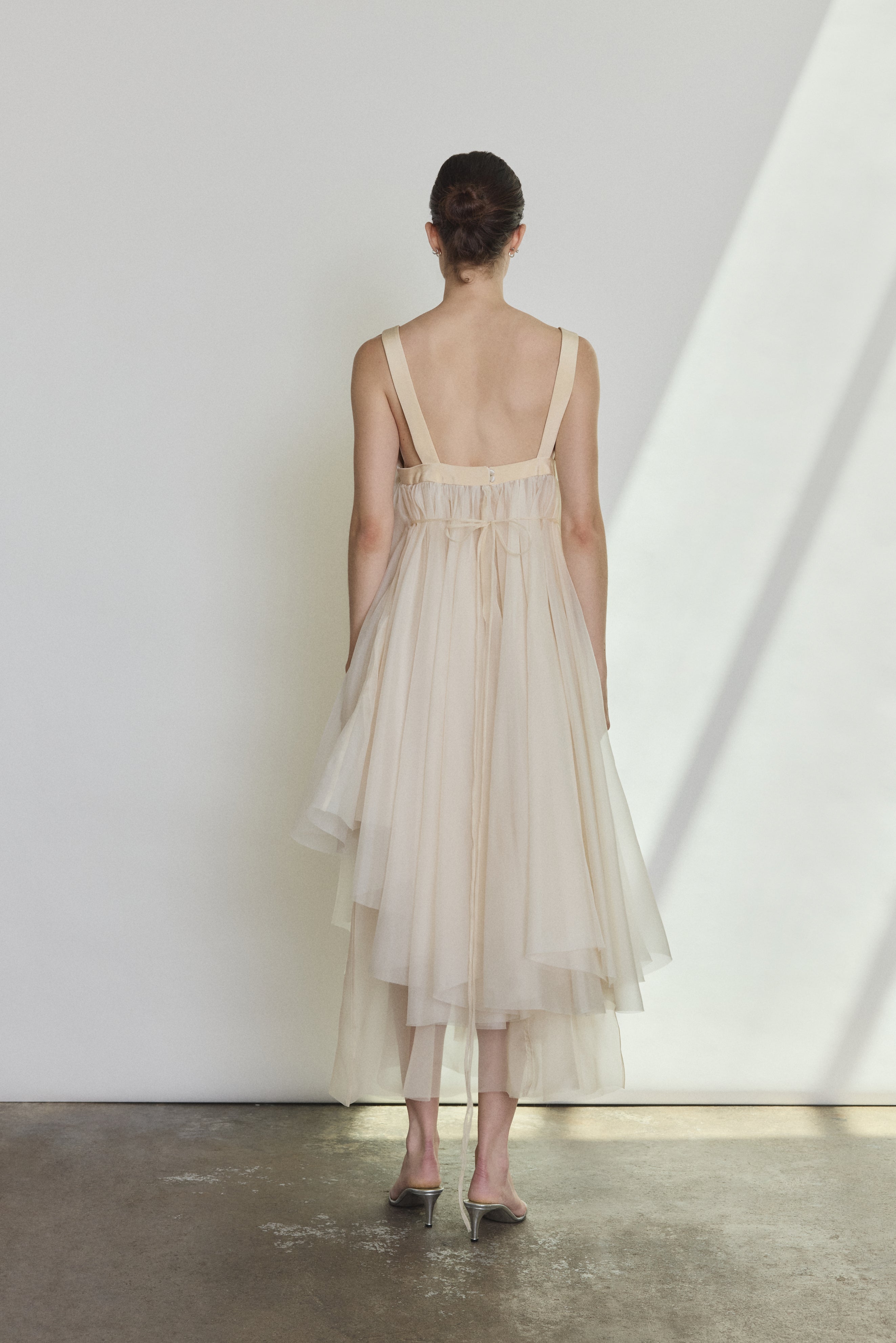 Back view of the ivory silk organza Kamperett Loie Dress with silk crepe straps and cord waist tie.