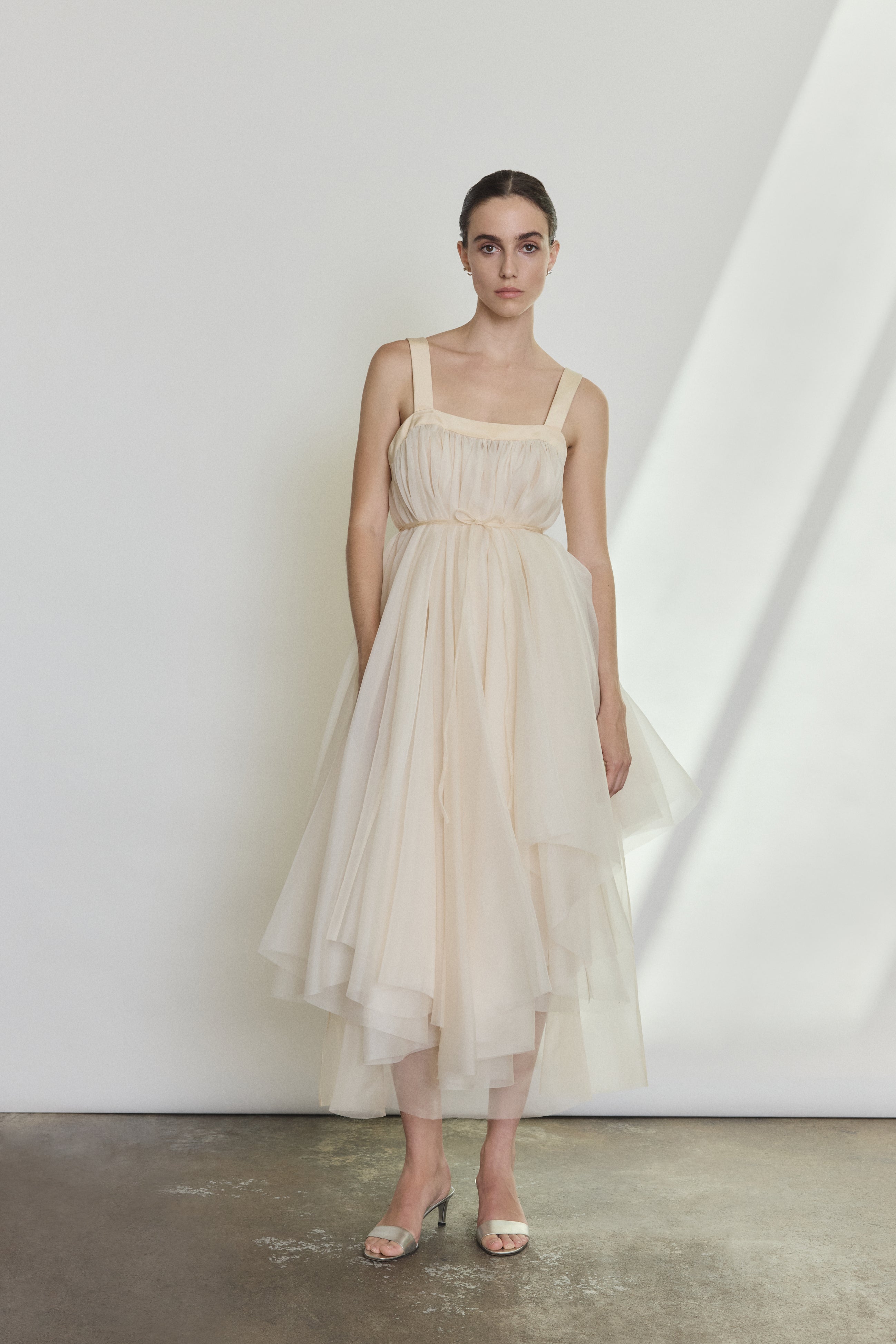 Detail of the ivory silk organza Kamperett Loie Dress showing the asymmetrical tier construction and silk cord waist.