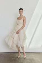 Editorial image of a bride wearing the ivory Kamperett Loie Dress, a modern bridal tiered silk organza midi.