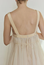 Editorial image of the ivory Kamperett Loie Dress styled with the silk cord defining the waist.