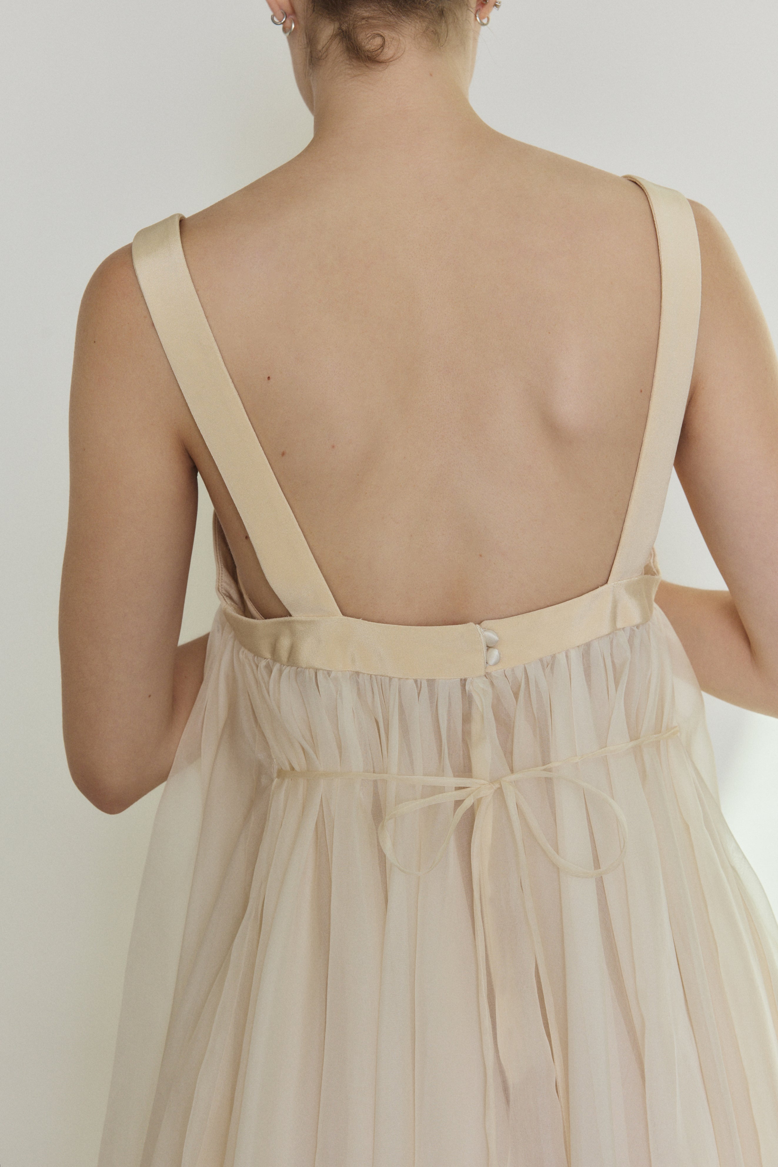 Editorial image of the ivory Kamperett Loie Dress styled with the silk cord defining the waist.