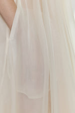 Editorial image of the ivory Kamperett Loie Dress showing the sheer organza tiers with motion.