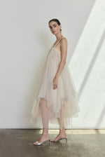 Side view of the ivory silk organza Kamperett Loie Dress showing the asymmetrical tiered silhouette and silk cord waist tie.