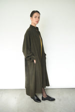 Angled view of the carob Lyocell Kamperett Lore Trench Coat showing the oversized swing silhouette.