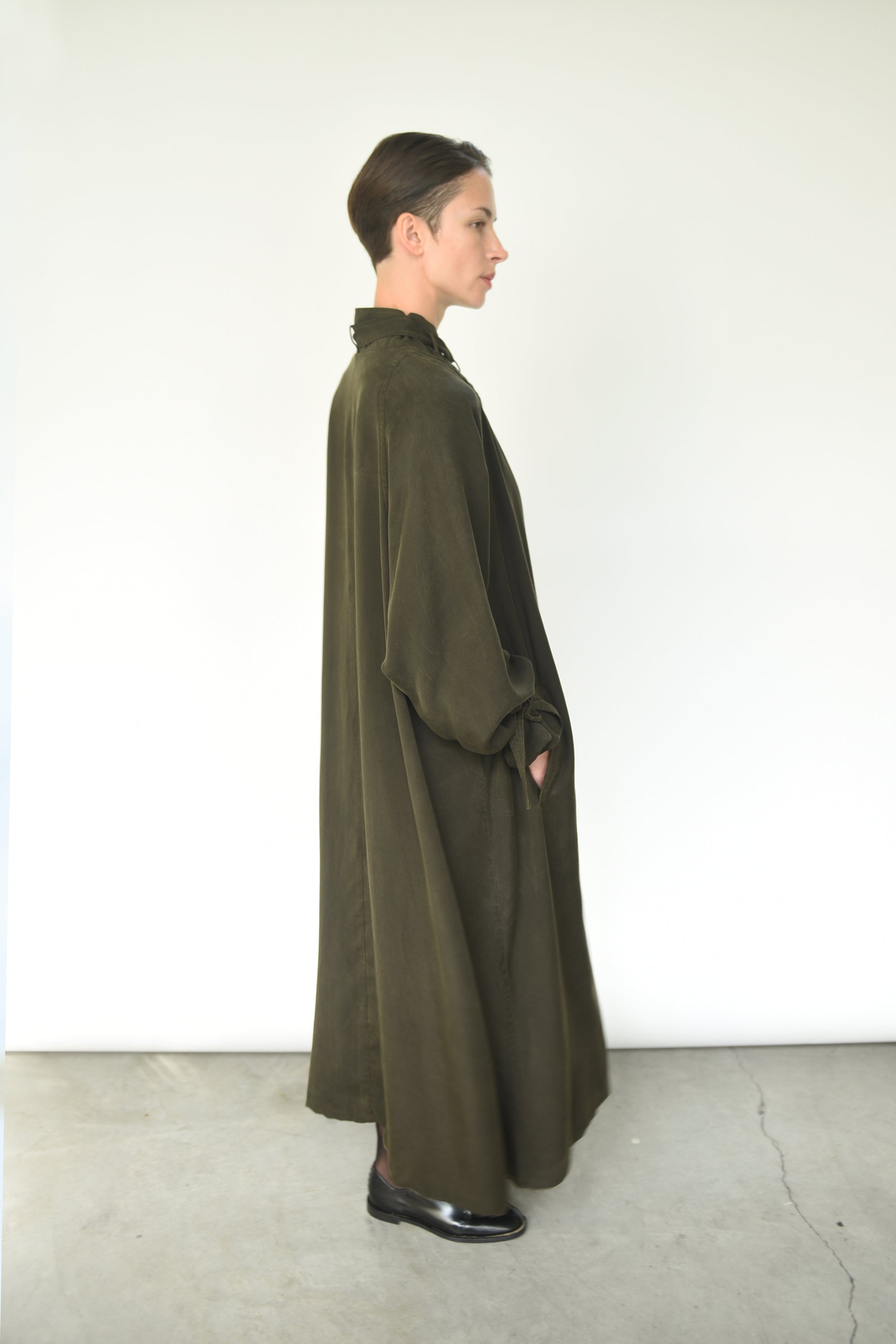 Detail of the mandarin collar and tie closure on the carob Kamperett Lore Trench Coat.