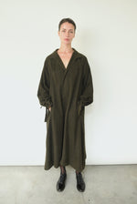 Front view of a model wearing the carob Lyocell Kamperett Lore Trench Coat, an oversized swing trench with mandarin collar.