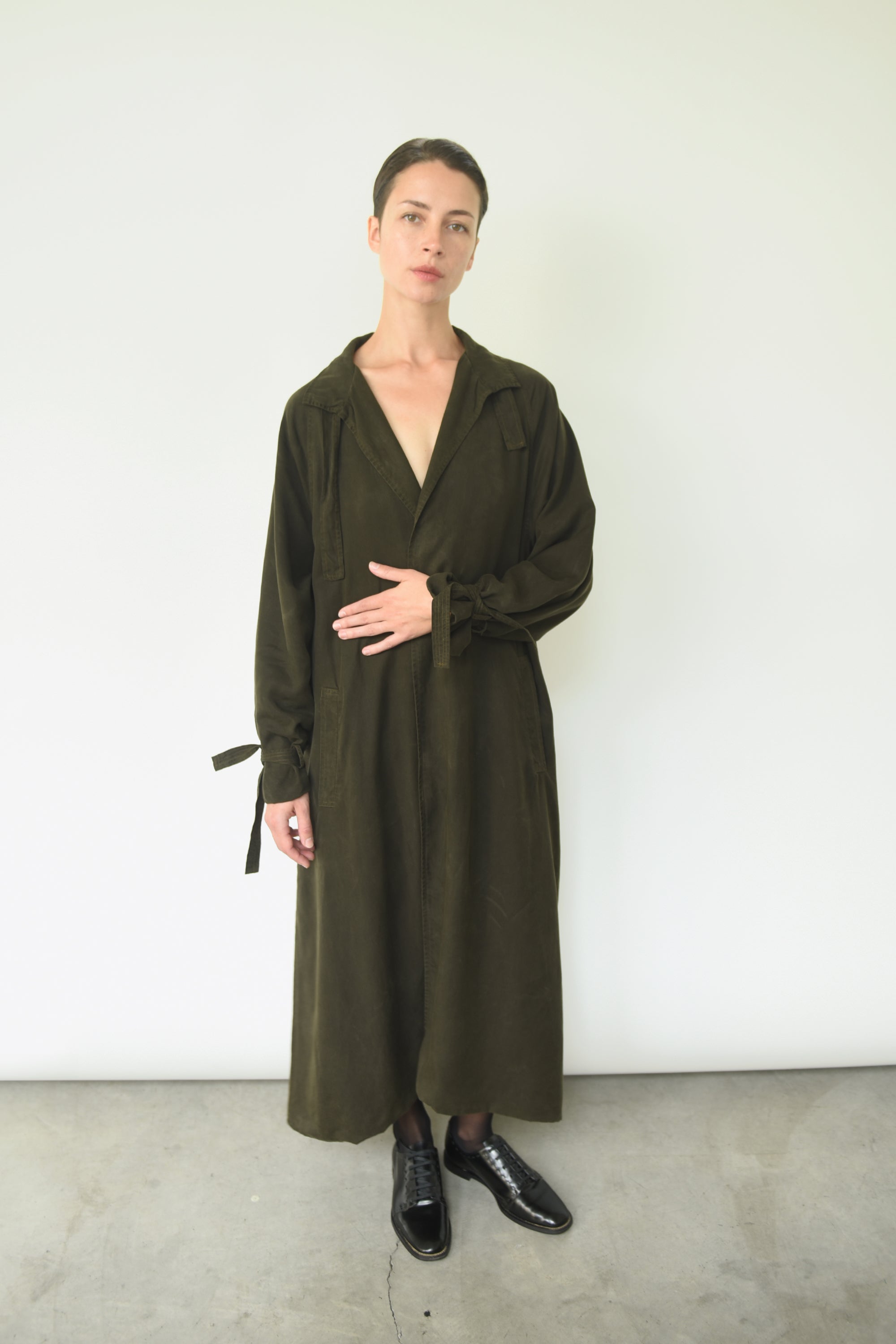 Styled view of the carob Lyocell Kamperett Lore Trench Coat with welt pockets at the front.