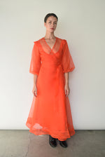 Angled view of the vermilion silk organza Kamperett Loretta Midi Dress showing the wrap closure.