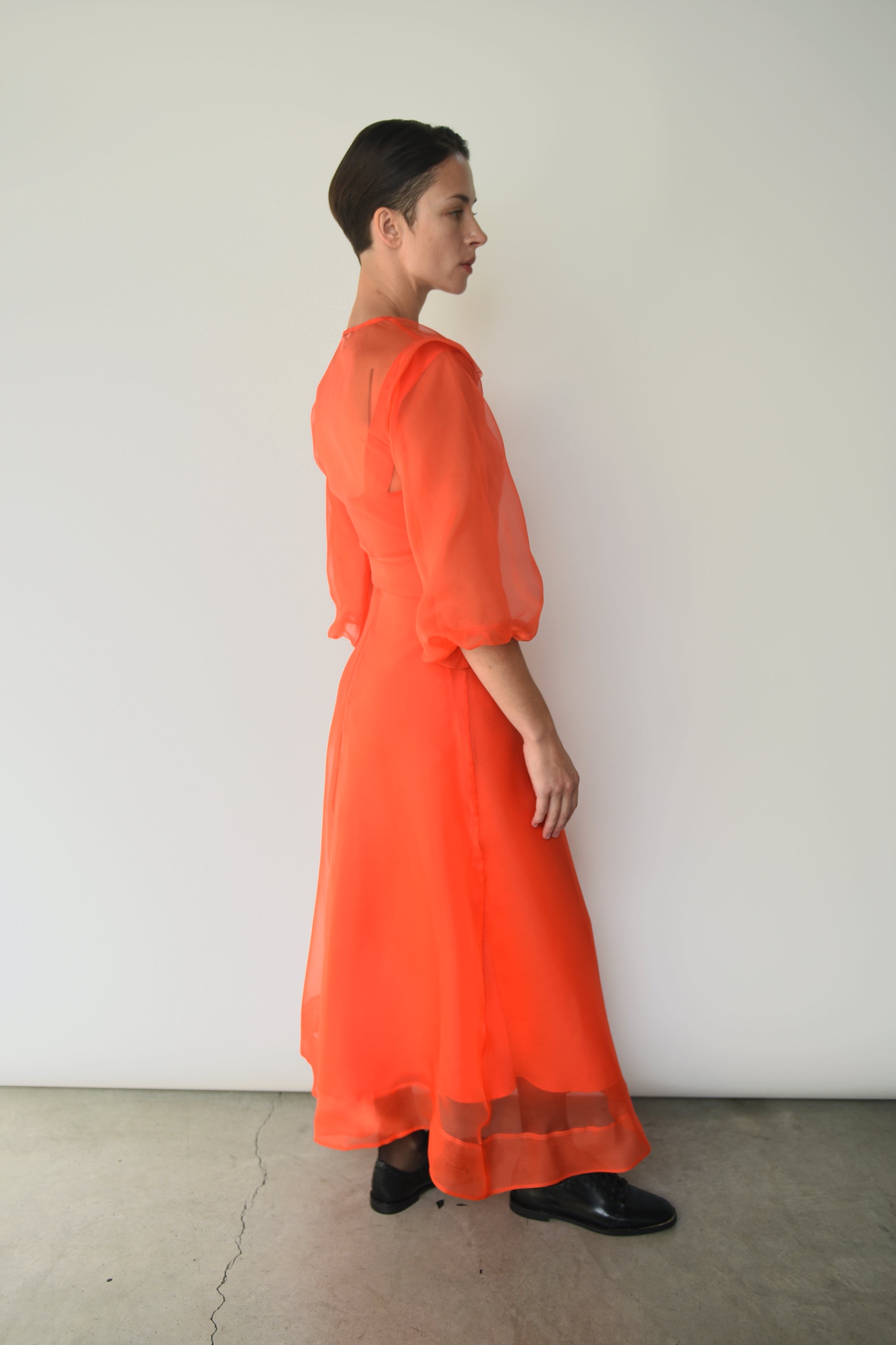 Side view of the vermilion silk organza Kamperett Loretta Midi Dress with full skirt.