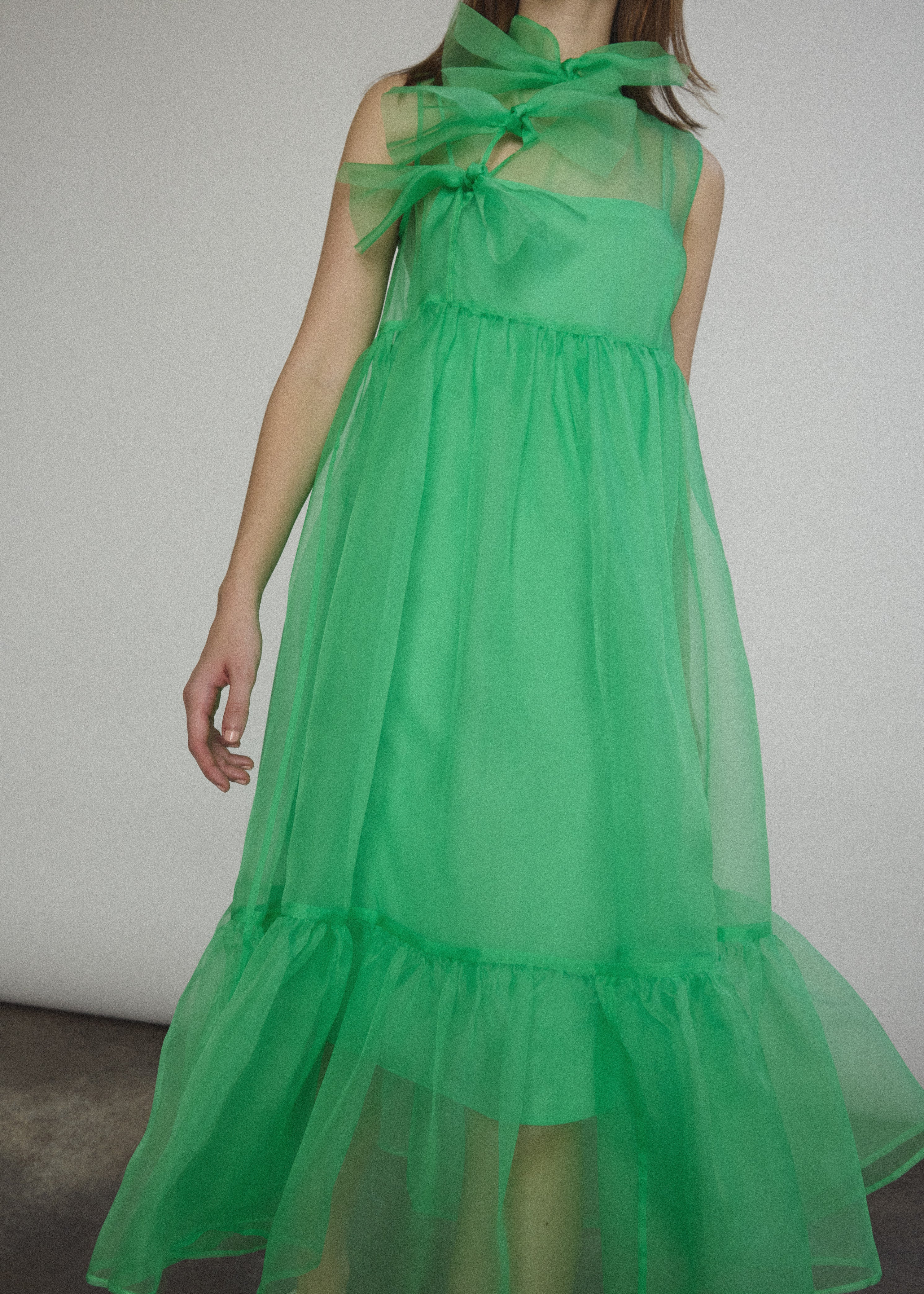 Side view of the celadon silk organza Kamperett Mae Dress showing the full skirt and gathered hem ruffle.