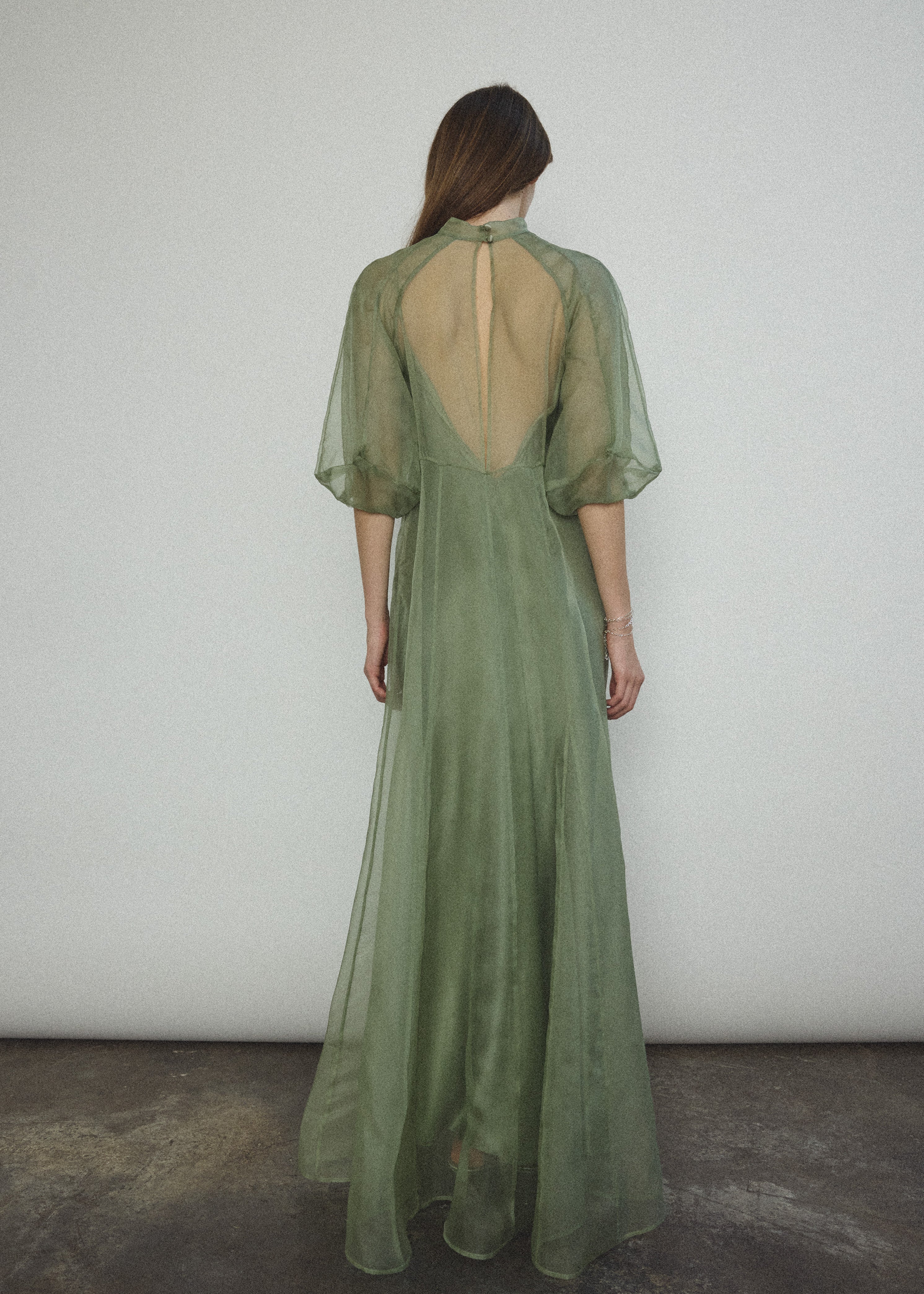 Angled view of the jade silk organza Kamperett Meiere Gown with fitted waist seaming.