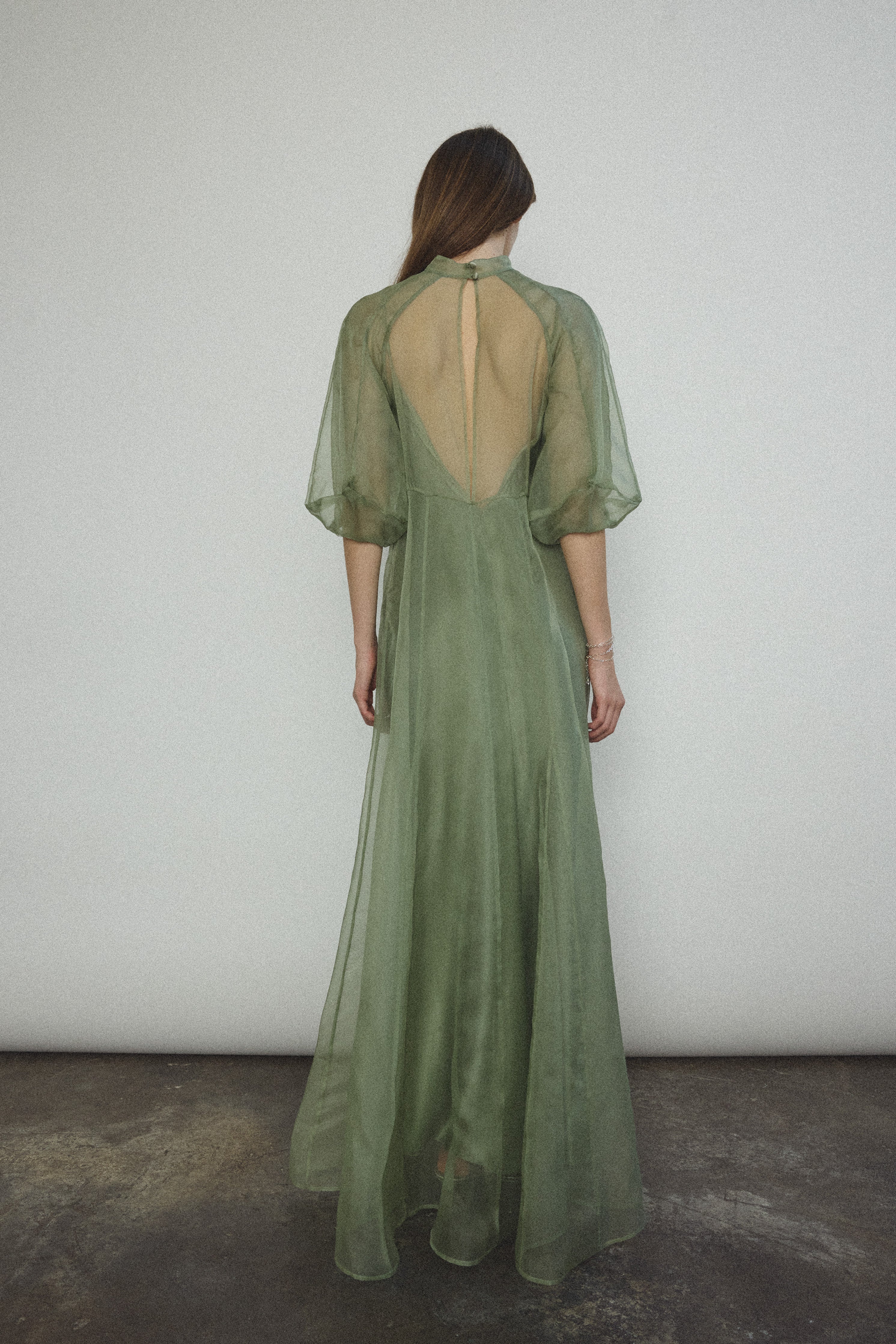 Angled view of the jade silk organza Kamperett Meiere Gown with fitted waist seaming.