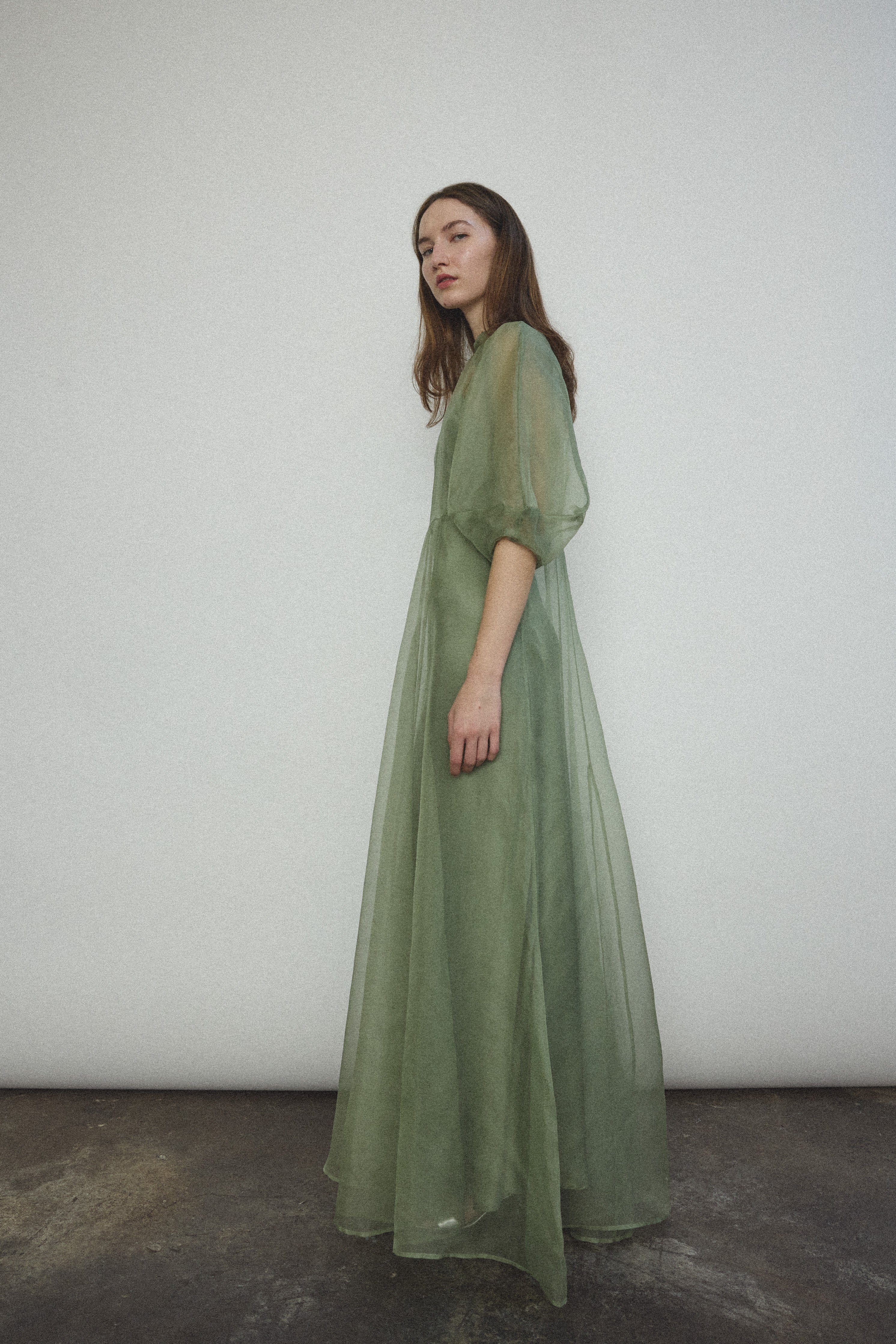 Back view of the jade silk organza Kamperett Meiere Gown with mock neck and back button closure.