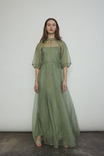 Front view of a model wearing the jade silk organza Kamperett Meiere Gown, with architectural sleeves and fitted waist.