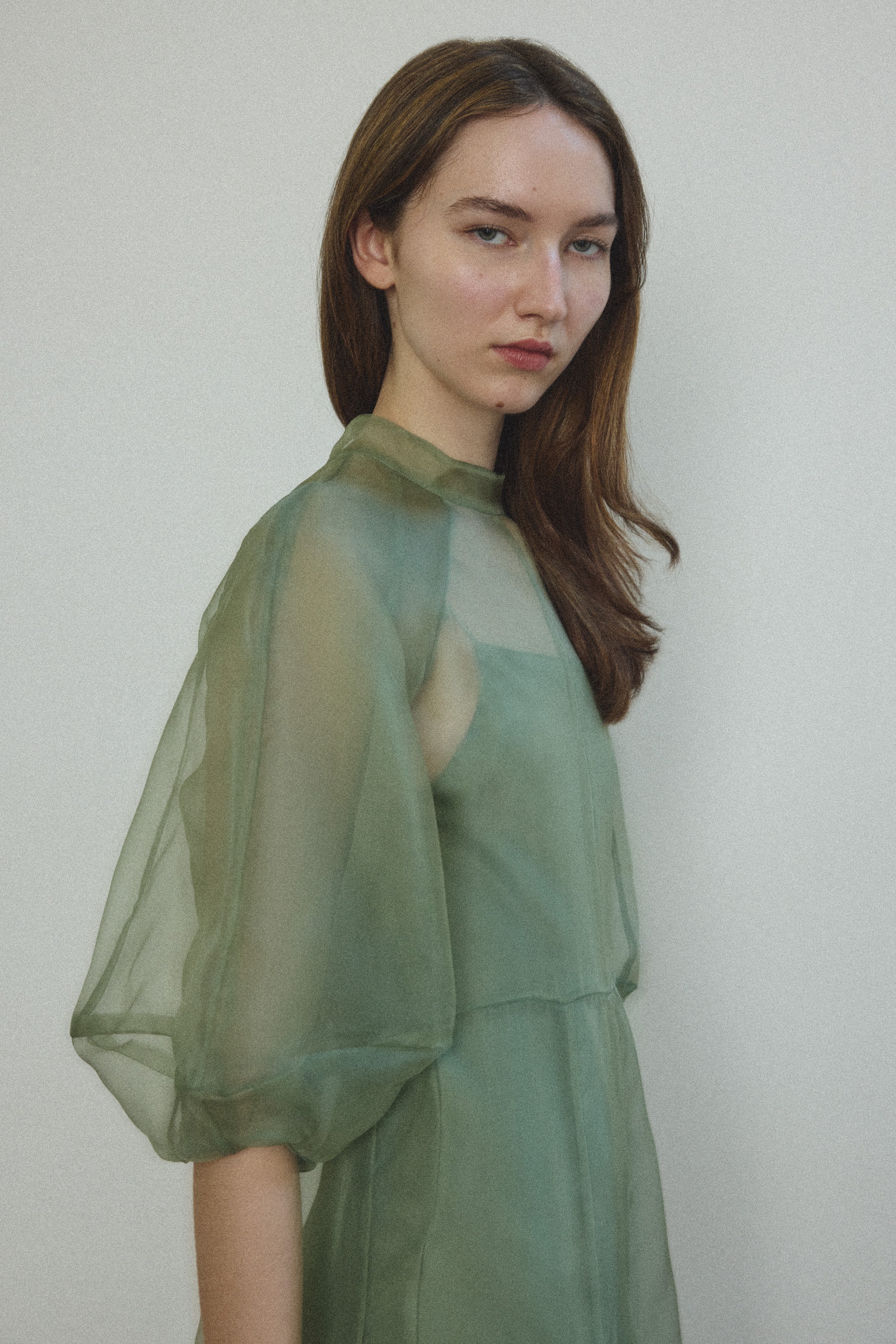 Motion shot of the jade silk organza Kamperett Meiere Gown, capturing the sweeping multi-godet skirt.