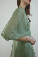 Detail of the architectural cut-glass-inspired sleeves on the jade silk organza Kamperett Meiere Gown.