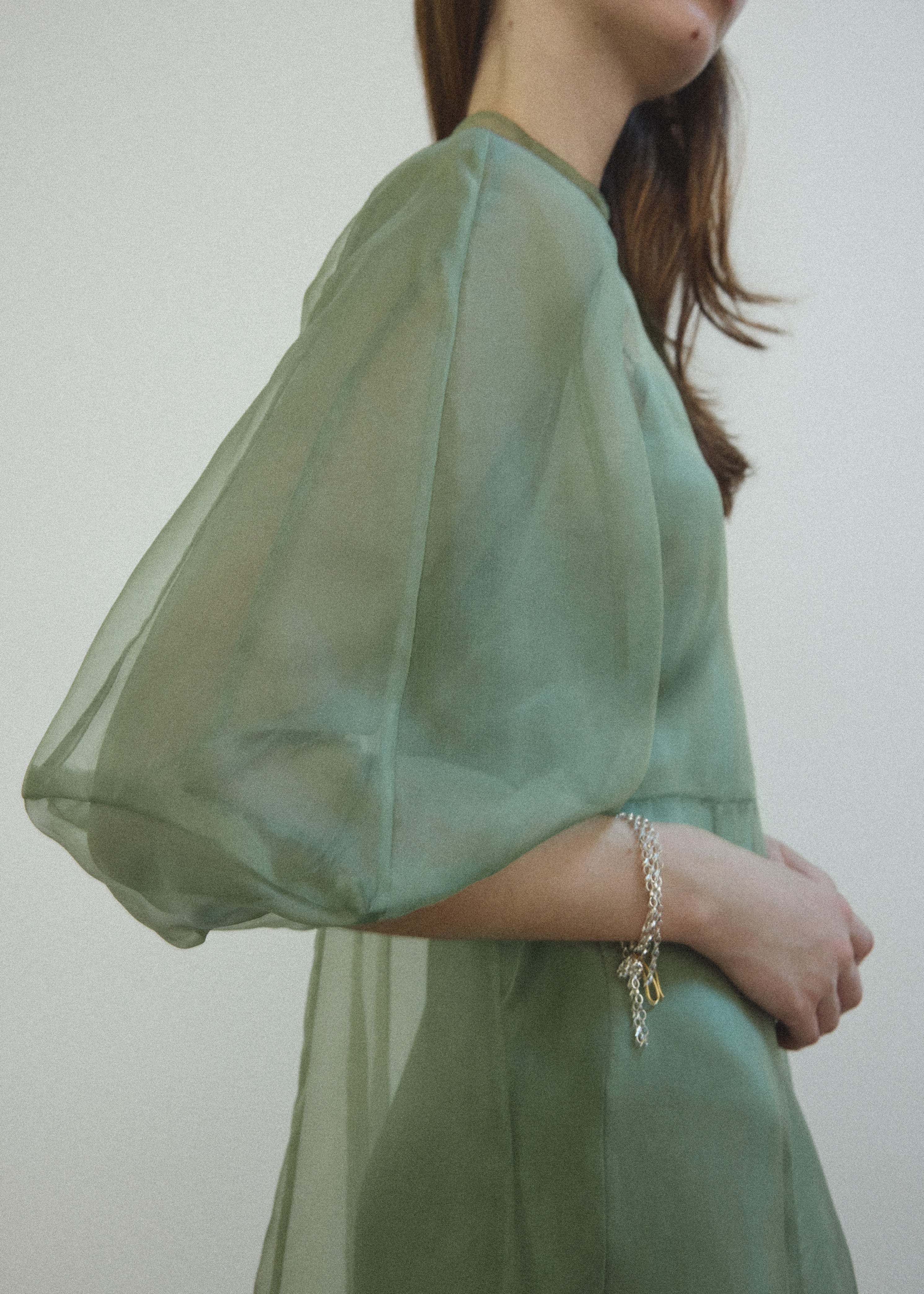 Detail of the architectural cut-glass-inspired sleeves on the jade silk organza Kamperett Meiere Gown.
