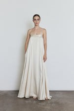 Front view of a bride wearing the ivory silk Kamperett Metronome Gown, a sleek column wedding gown with sweeping hem and corded straps.