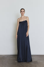 Front view of a model wearing the midnight silk Kamperett Metronome Gown, a sleek column gown with sweeping hem and corded straps.